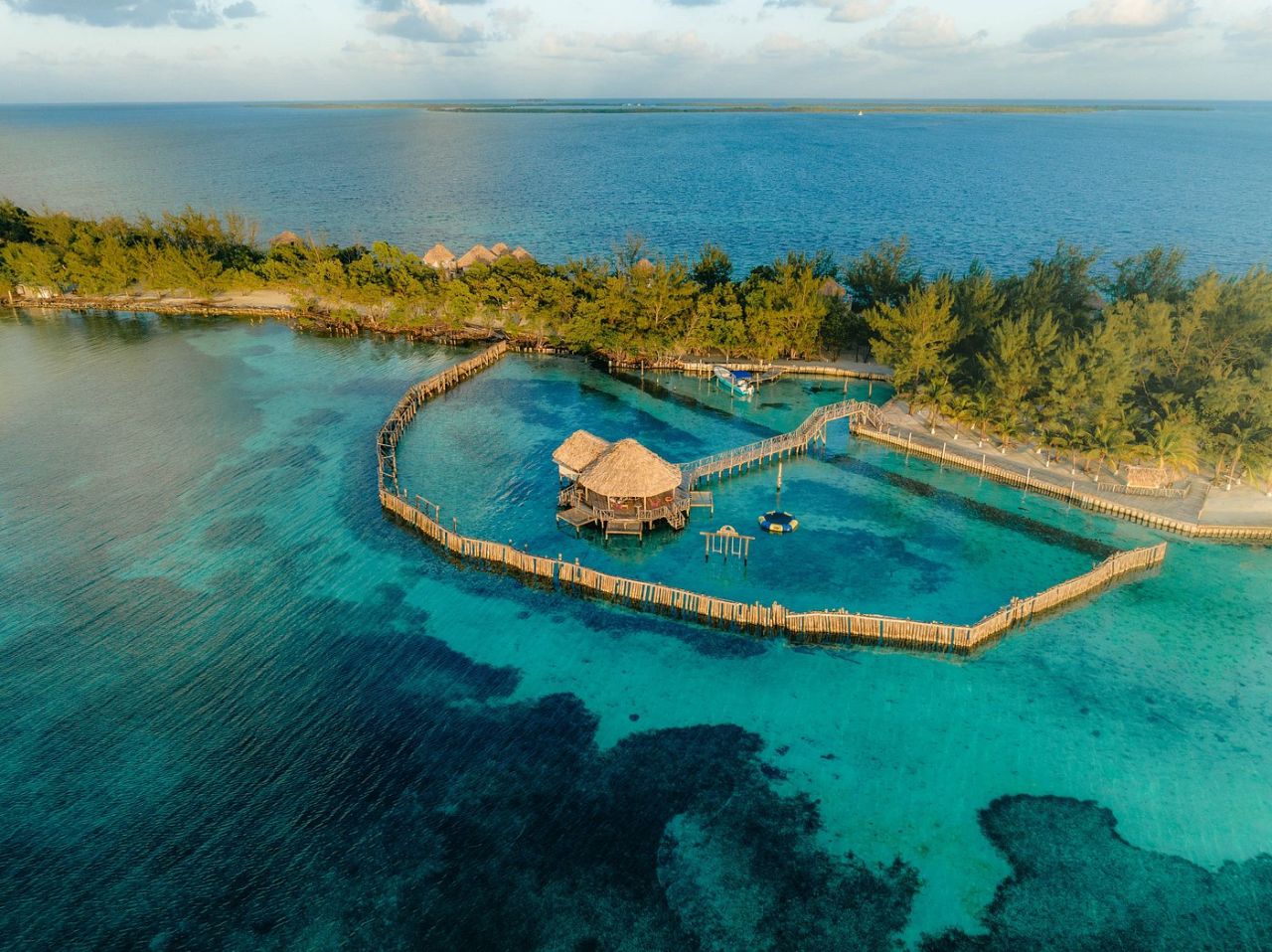 Aerial view of Thatch Caye private island resort in Belize with overwater bungalows and turquoise Caribbean water